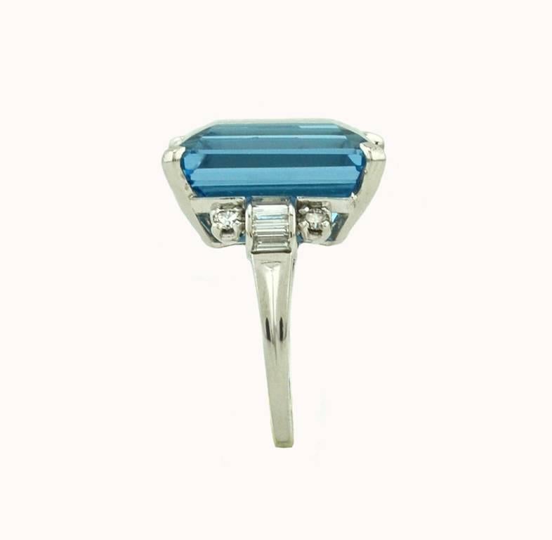 An incredible 1950s Tiffany & Co. platinum ring with the most gorgeous aquamarine center stone.  A deeply saturated 15.01 carat Santa Maria aquamarine at the center with 8 diamond baguettes and 4 round diamond side stones.  The diamonds are G-H in