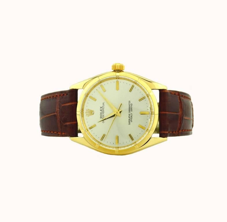 A classic Rolex Oyster Perpetual wristwatch in 14 karat yellow gold, reference 1003. This beautiful Rolex features a 14 karat yellow gold oyster case, a 14karat yellow gold engine turned bezel, plastic crystal, silvered satin original dial, with
