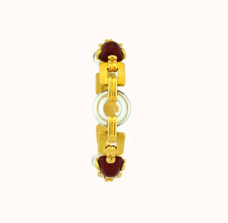 A very cool retro 18 karat yellow gold link bracelet from circa 1950.  This bracelet features 3 carnelian sugar loaf cabochons and 3 rock crystal discs with semi-matte gold links in between.  

This bracelet measures approximately 7.5 inches in
