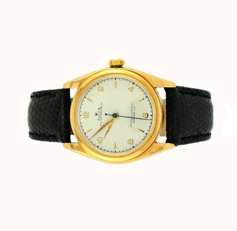Rolex Oyster Perpetual wristwatch in 14 karat yellow gold, reference 4392. This classic Rolex watch features a 14K yellow gold case, a white refinished dial,  a bubbleback movement number 5696XX and a locking bubble back gold crown. The case
