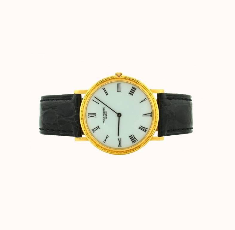 Patek Philippe Calatrava wristwatch reference 3744 from circa 1980s-1990s. This classic dress model wristwatch features a 18 karat yellow gold hobnail case, white color porcelain dial with roman numeral dial, glass crystal, and a Patek Philippe