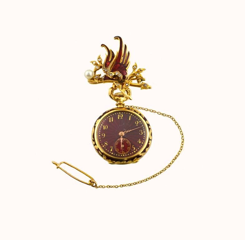 A fabulous example of a turn of the century (circa 1900s) pendant pocket watch. This beautiful antique pendant watch features a 18 karat yellow gold griffin with red enamel and small rose cut diamonds with one small pearl. The pocket watch features