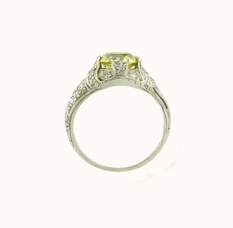 A stunning Edwardian platinum engagement ring from circa 1910.  This ring features a 1.61 carat natural fancy yellow diamond that is SI in clarity per GIA certificate.  The beautiful glow of the yellow diamond is truly magical! The platinum setting