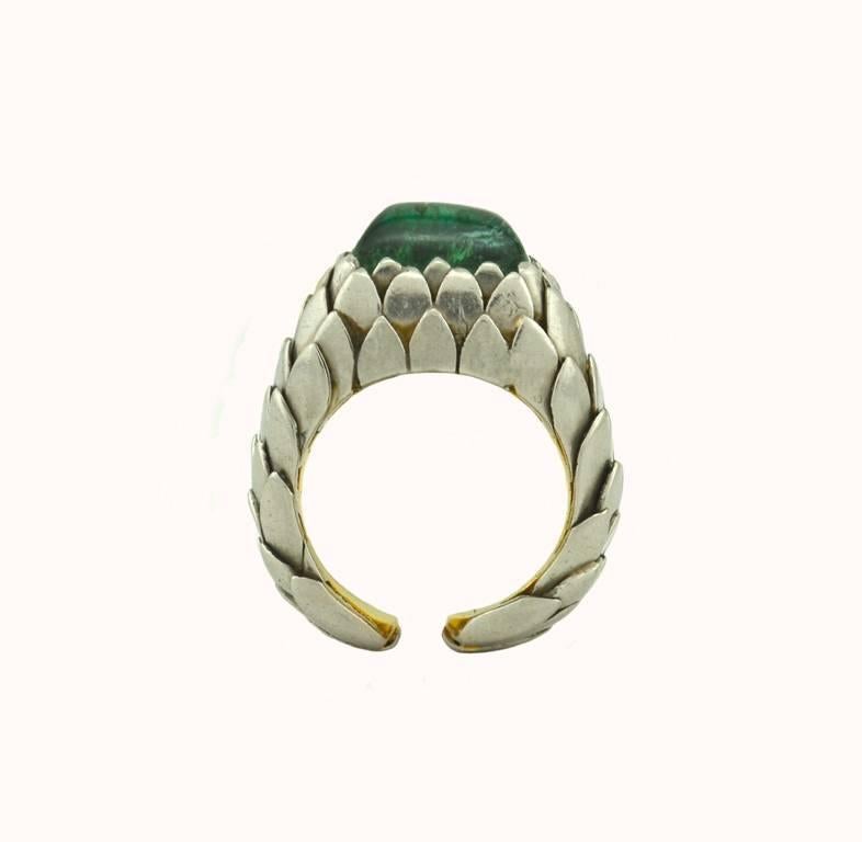 A very cool green tourmaline sugarloaf ring from circa 1970s-1980s.  The tourmaline is set in 18 karat white and yellow gold in stylized feather pattern which gives a sculptural feel to this piece.

This ring is a US size 5.75 and can not be