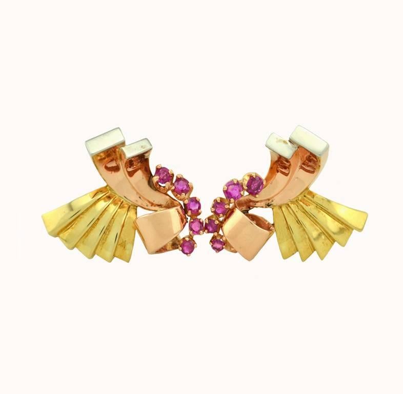Vintage retro clip-on earrings in 14 karat pink, yellow, and white gold from circa 1940.  These cool earrings features 10 rubies (5 on each earring) and lovely scrolling design in tri-gold.  

These earrings are approximately 1.07 inches in height,