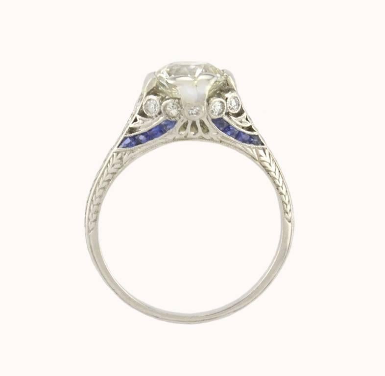 An Edwardian diamond and platinum engagement ring with sapphire accents from circa 1910-1920.  This beautiful ring features a 1.54 carat Old European Cut diamond at the center that is J in color and VS2 in clarity (per GIA certificate). 