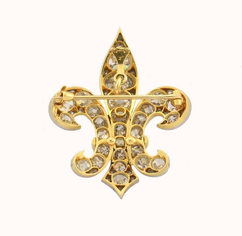 An incredible antique fleur-de-lis large diamond brooch/pendant.  This incredible piece is platinum topped 18 karat yellow from circa 1895 and features 13 carats of Old Mine Cut diamonds!!! The diamonds range in color from I-J to S-T-U fancy light