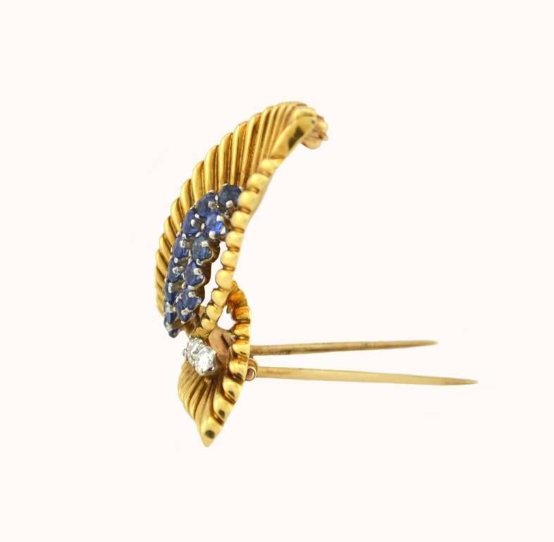 A lovely Van Cleef and Arpels 18 karat yellow gold leaf clip from circa 1950 with 13 round brilliant sapphires and 3 round brilliant diamonds. Signed Van Cleef & Arpels NY.

This clip measures approximately 1.32 inches in length, and 1.15 inches in