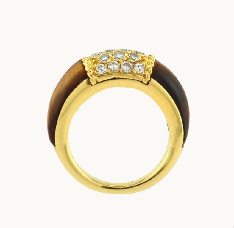 Van Cleef & Arpels Philippine ring with 18 round diamonds in 18 karat yellow and tiger's eye. These rings look great stacked with others as well as on their own! 

This ring measures approximately 7 millimeters in width and 6 millimeters in depth