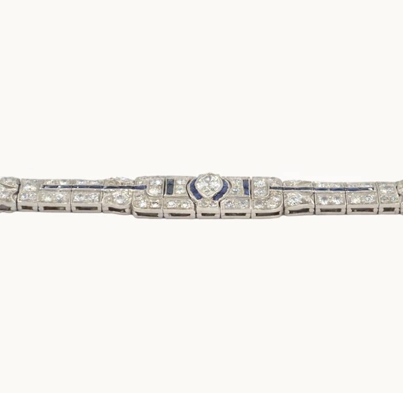 Art Deco diamond and sapphire platinum bracelet from circa 1930s.  This pretty link bracelet features 73 diamonds that total 4.5 carats in total diamond weight and features a 0.40 carat marquise cut diamond at the center further accented by calibre