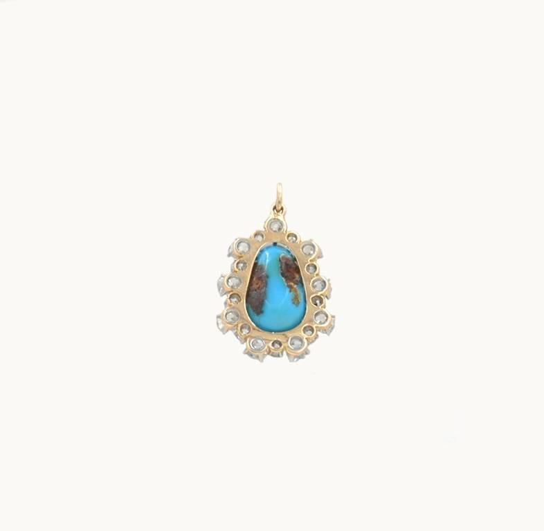 Victorian turquoise and diamond cluster pendant in 18 karat yellow gold from circa 1890.  This stunning pendant features a bright blue piece of Persian turquoise surrounded by 18 Old European and Old Mine Cut diamonds, which total to approximately