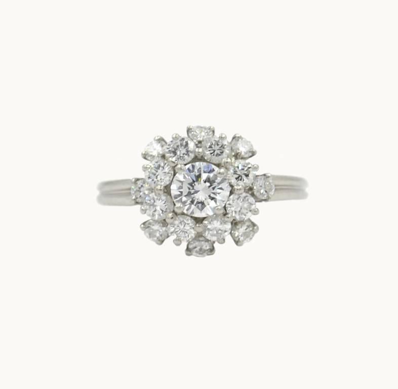 Oscar Heyman diamond cluster platinum ring from circa 1980. This gorgeous ring features a 0.60 carat round brilliant cut center diamond with 16 round brilliant cut side diamonds that total approximately 1.20 carats in diamond weight.  The diamonds