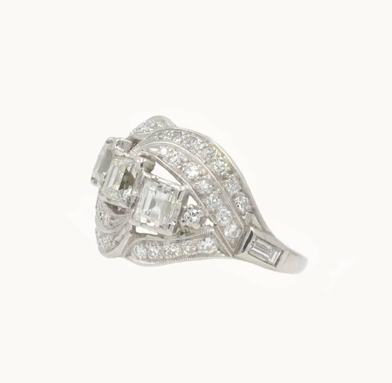 A vintage platinum and diamond ring from circa 1930.  This unique ring features 3 square cut diamonds each approximately 0.35 carats that total 1.05 carats in diamond weight and are G-H in color and VS in clarity.  Additionally, 40 single cut