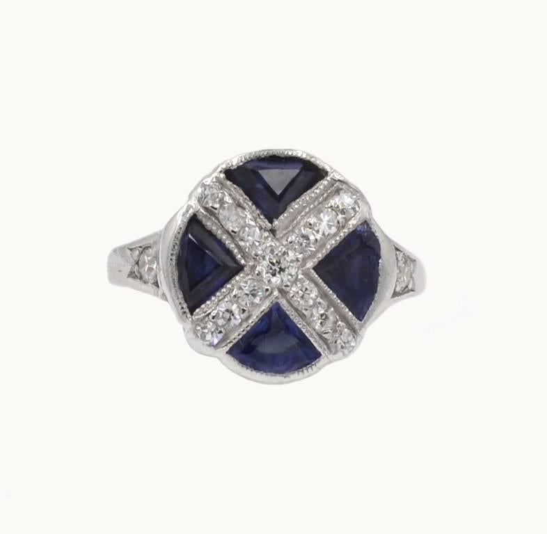 Art Deco platinum ring from circa 1930s that features four calibre cut synthetic sapphires and 13 old single cut round diamonds. A very cool, unique ring!

Currently a US size 5 and easily adjustable.
This ring measures approximately 0.46 inches in