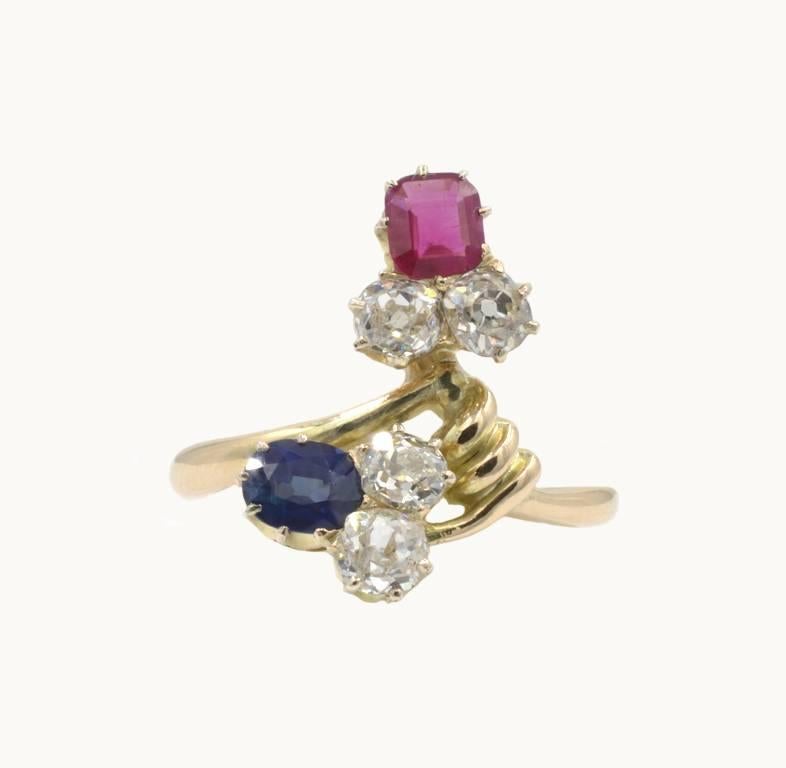 An antique Russian ring from circa 1910 in 14 karat yellow gold. This beautiful ring features a 0.55 carat natural sapphire and 0.40 carat natural ruby along with four Old Mine Cut diamonds that are H-I in color and VS-I1 in clarity, each