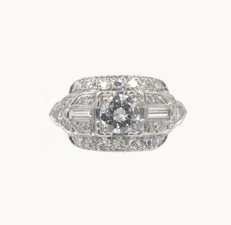 A vintage diamond and platinum engagement ring from circa 1950s.  This pretty ring features a center 0.46 carat round brilliant cut diamond that is D in color and VS1 in clarity (per EGL certificate).  The center diamond is flanked by two diamond
