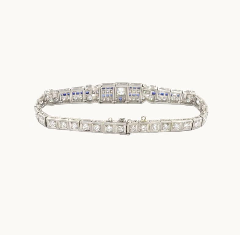 Art Deco platinum and diamond link bracelet with sapphire accents from circa 1920. This beautiful bracelet features a center 0.75 carat Old European Cut diamond with 84 additional Old European Cut side diamonds which totals approximately 7 carats in