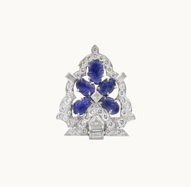 Raymond Yard Art Deco diamond and sapphire clip brooch from circa 1930s.  This beautiful piece features 5 carved blue sapphires and a total of 2 carats of diamond weight with 44 round brilliant cut diamonds, 1 triangular diamond, and 6 baguette