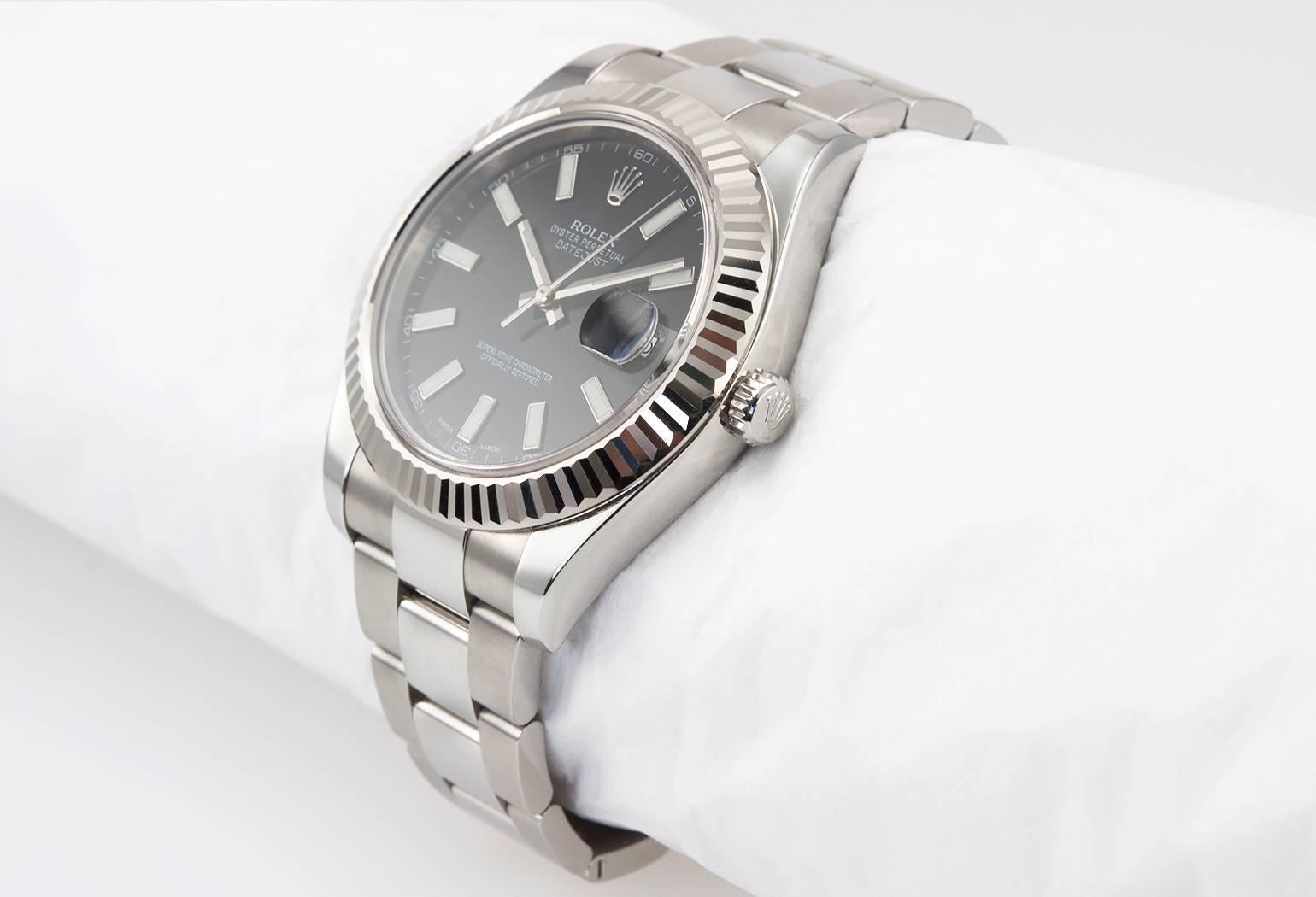 Rolex DateJust II wristwatch in stainless steel with a 18K white gold fluted bezel, reference 116334. This Rolex watch features a black dial with white stick markers, stainless steel Oyster bracelet, sapphire crystal, steel waterproof crown. The