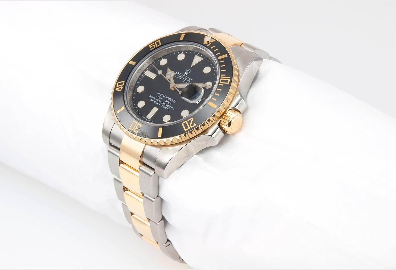 Rolex Submariner in stainless steel and 18K yellow gold, reference 116613.  This classic Rolex watch features a black ceramic bezel, a black dial, sapphire crystal, 18K yellow gold waterproof crown, with an 18K yellow gold  and stainless steel