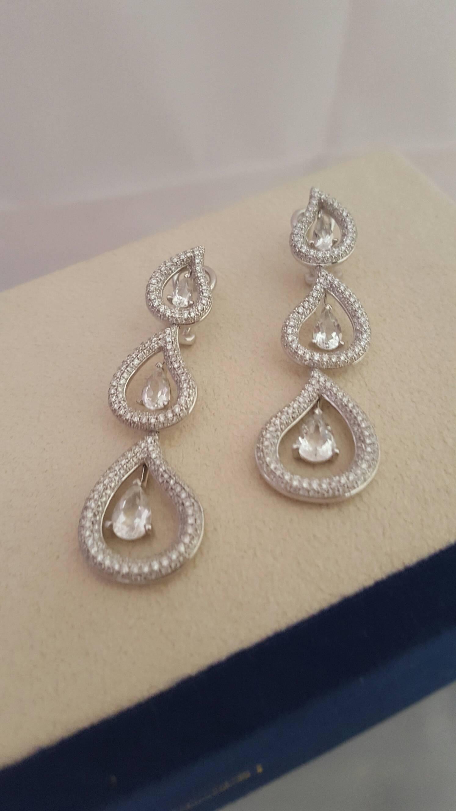 Elegant 18k White Gold Earrings enveloped in 2.56ct White Diamonds with 3ct graduated Topaz drops. Complete the look with matching Seafoam Drop Pendant.