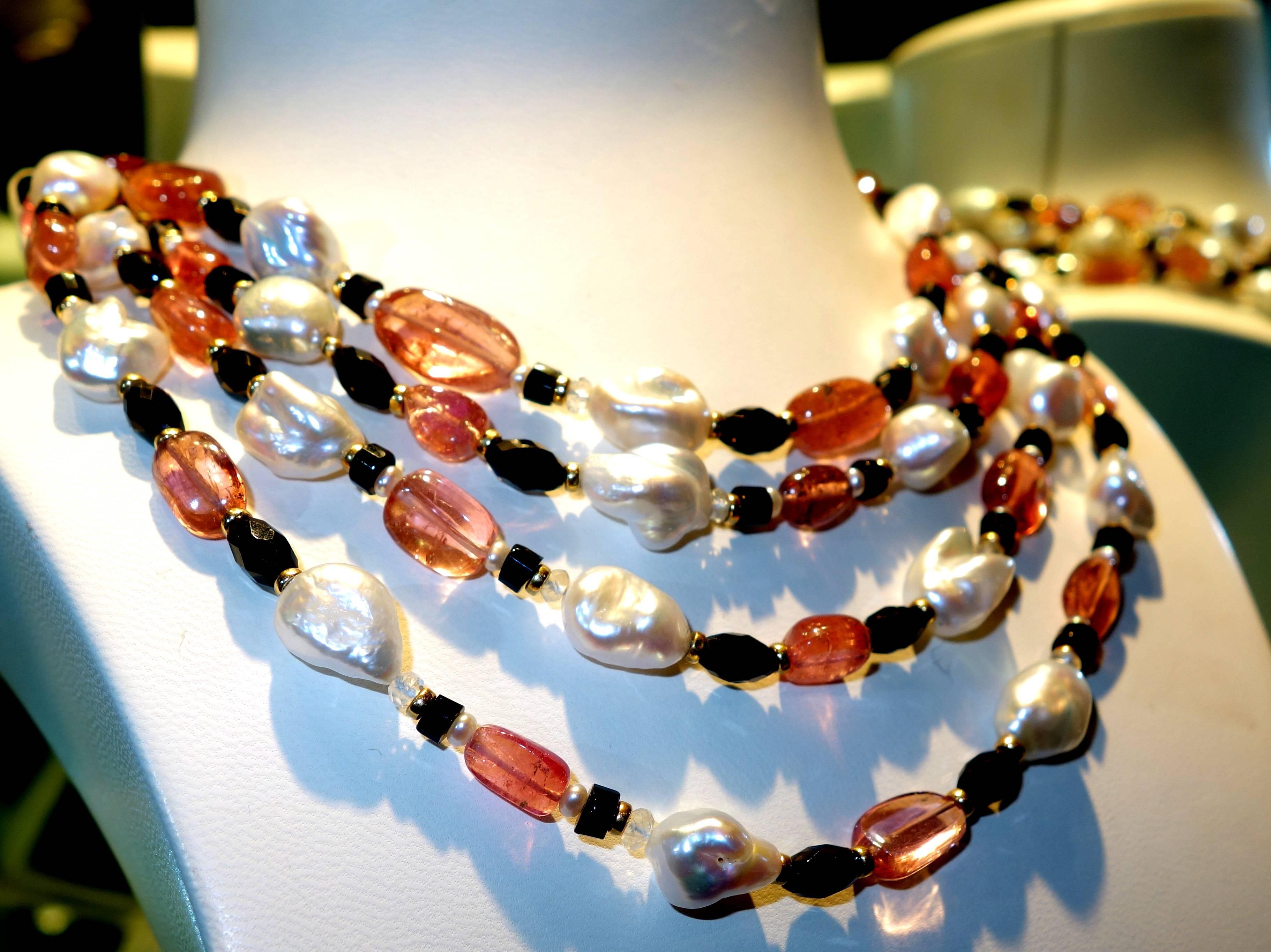 The free form pink tourmaline is a bright strong pink color it is accented with white baroque pearls, onyx and 18K gold beads.  This long necklace is 71 inches in length