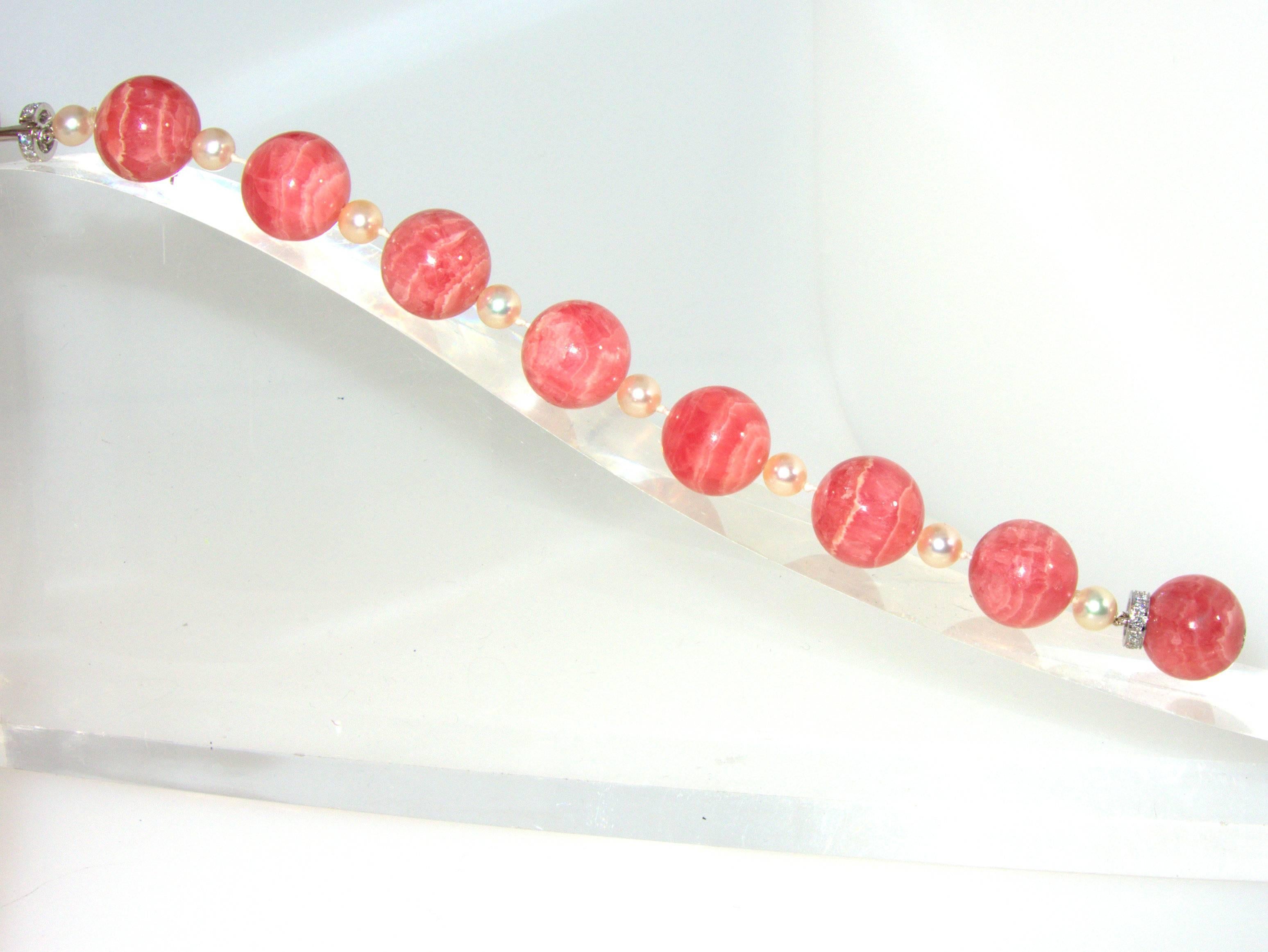 16 mm spheres of the unusual stone Rhodochrosite are interspersed with white pearls and finished with a diamond clasp.  Rhodochrosite comes from Argentina and one rarely sees the stone and especially in such finely cut round balls.  