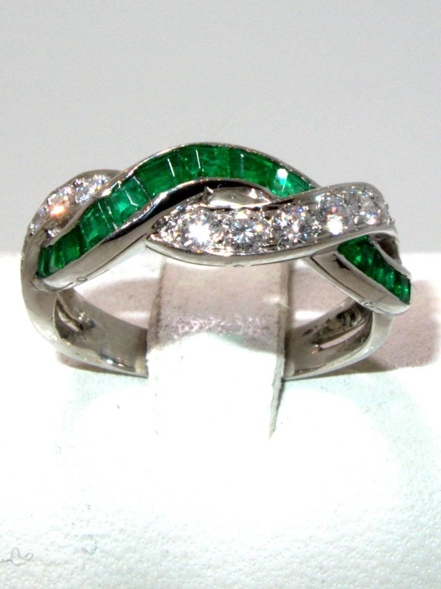 Of a twisted design, this classic ring by Oscar Heyman has 14 fine emerald cut emeralds and 12 round diamonds.  It is a size 5.5.