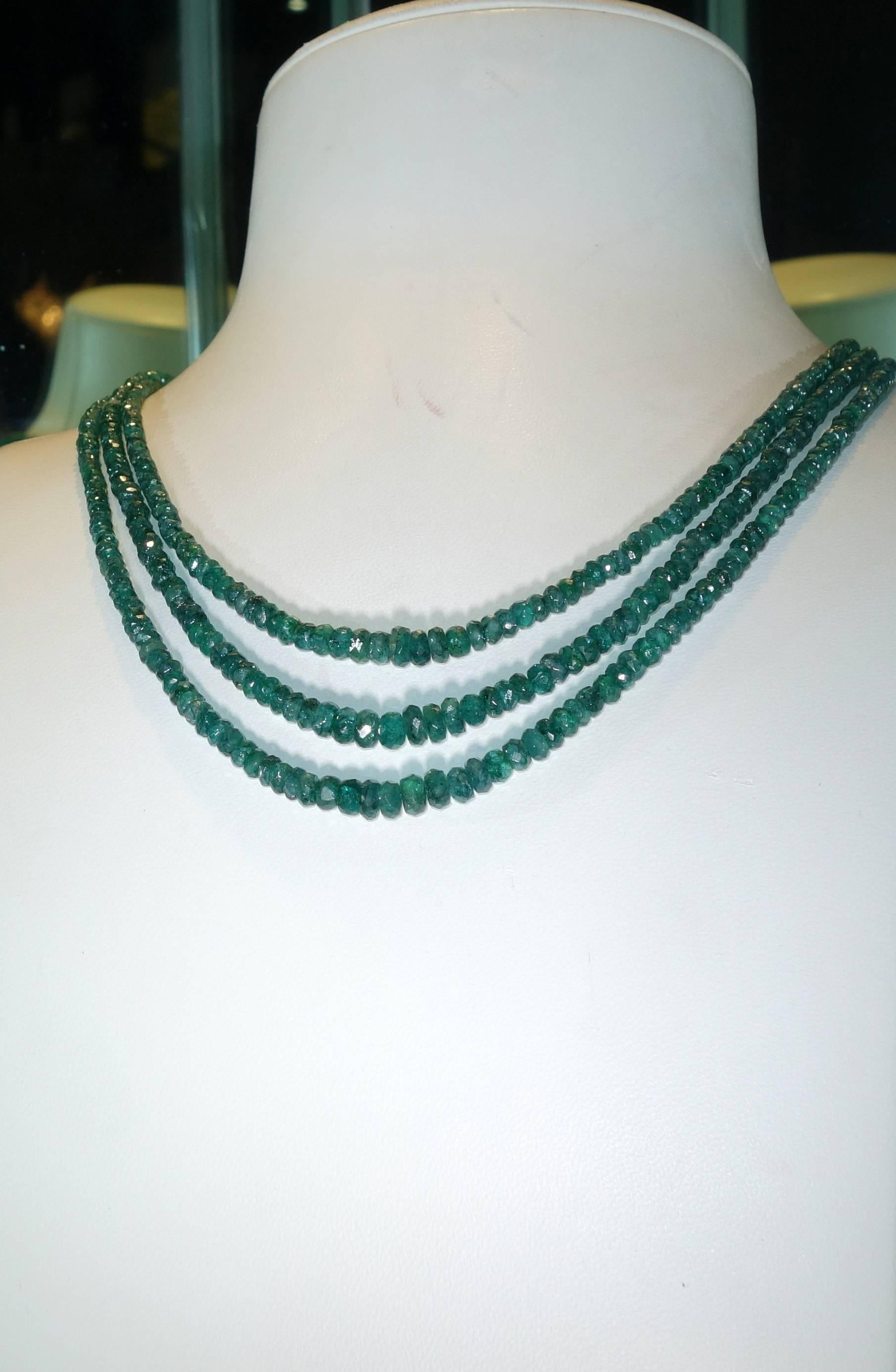 Finished with an 18K gold clasp, this necklace is three strands of natural faceted graduating emerald beads weighing approximately 145 cts.   The length of this necklace is 18.75 inches long and is a bright green statement for the neck.