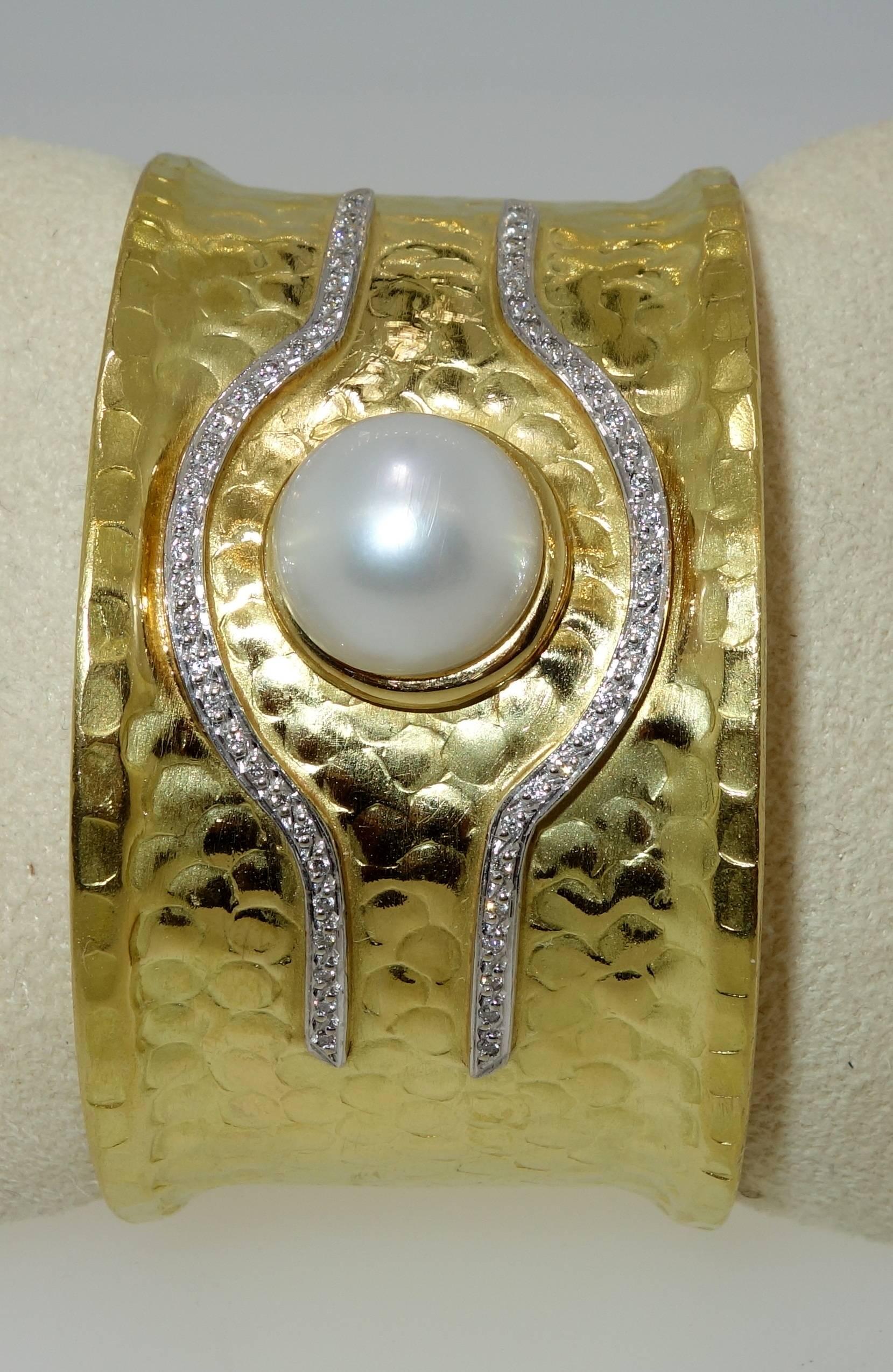 The mabe pearl is 13.4 mm and displays a fine unblemished surface.  There are 58 diamonds all well matched and near colorless (H) and very slightly included.  These diamonds weigh approximately .50 cts.  This cuff bracelet will fit most wrists and