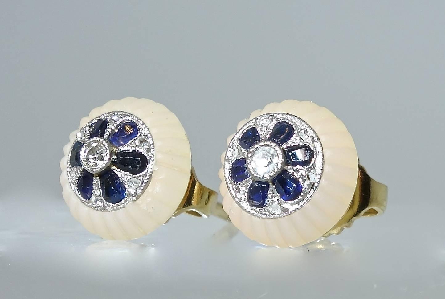 Fluted rock crystal with a platinum (with gold backing) center possessing 12 natural bright blue sapphires with an European cut diamond in the center and small rose cut diamonds set in between all creating a pretty flower motif.  These