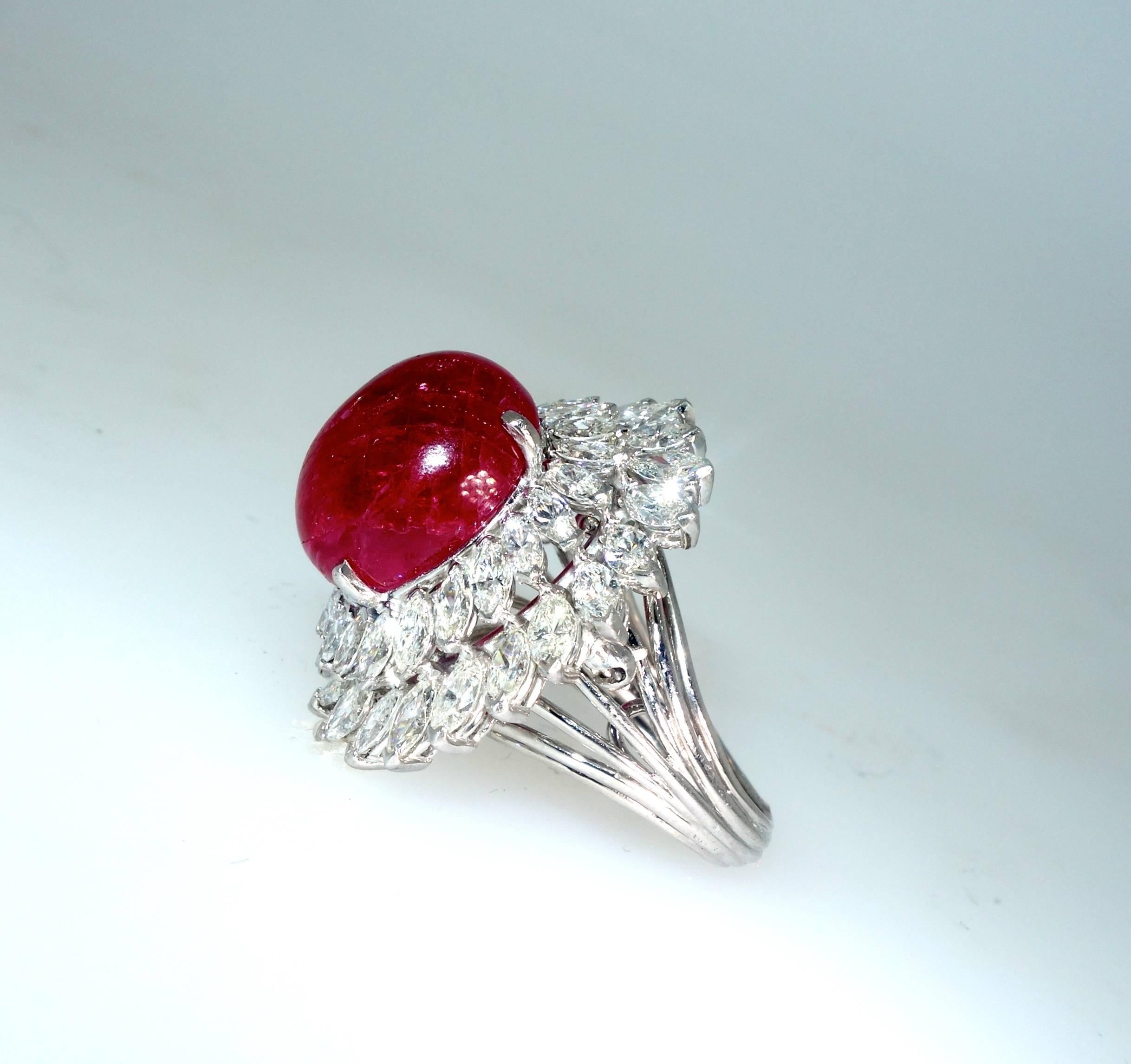 The cabochon cut center natural ruby is reminiscent of a bright red jelly bean!   The stone weighs at least 19 cts.  It is surrounded by fine white marquis cut diamonds. The  ruby has been examined by the American Gemological Laboratory and is