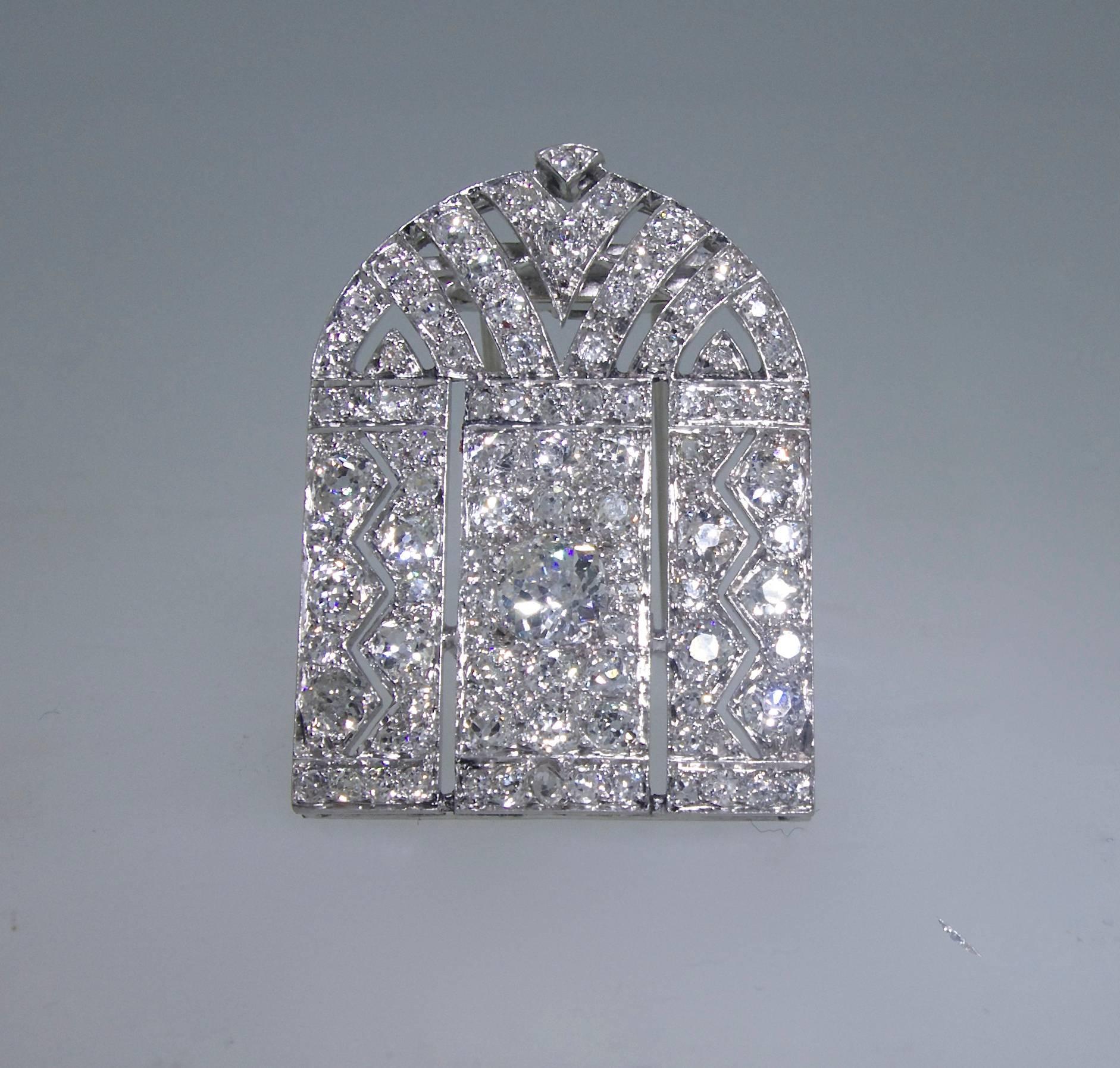 Centering a .78 ct old mine cut diamond which is surrounded in a geometric design by matching mine cut diamonds - these diamonds are bead set and near colorless and slightly included.  There are approximately 4.5 cts. totally of diamonds.  The