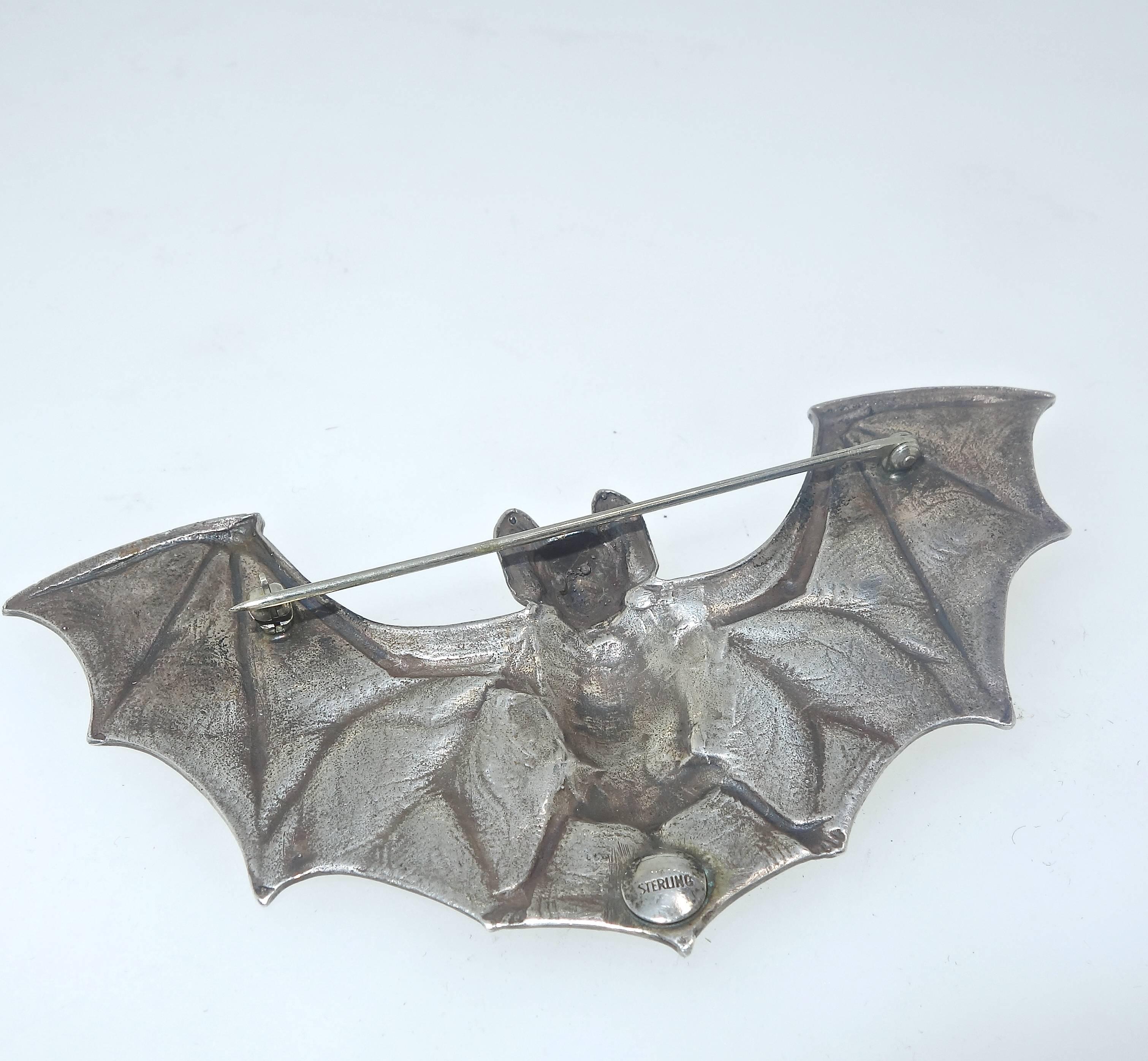 A popular Art Nouveau motif, this bat with wings spread is four inches in length.  He is well designed with red stone eyes and a smiling face!  Circa 1900