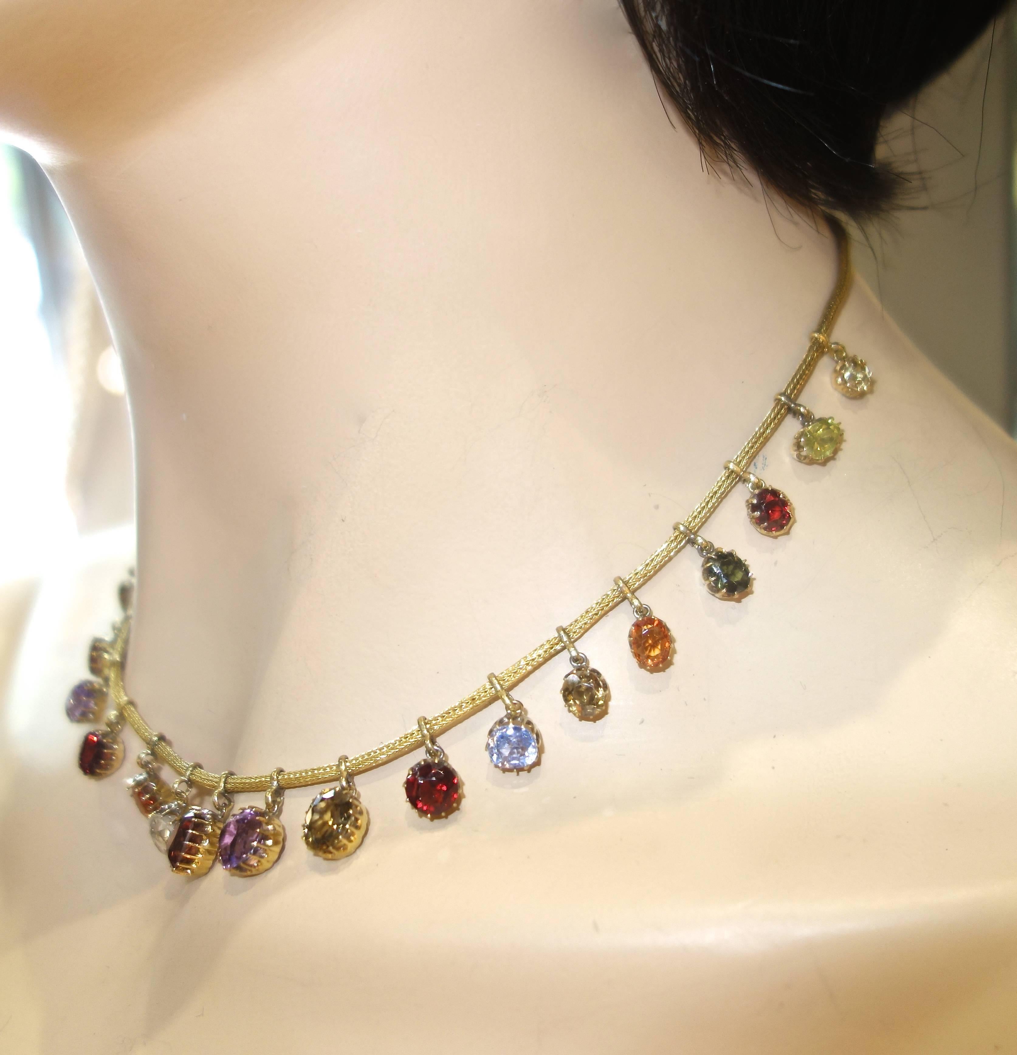 Antique cut with multi prong settings, these 21 natural stones: garnet, citrine, tourmaline, sapphire, zircon, amethyst and peridot are all suspended on a woven gold necklace.  The necklace is 16 inches long.  Colorful and unique, this necklace is
