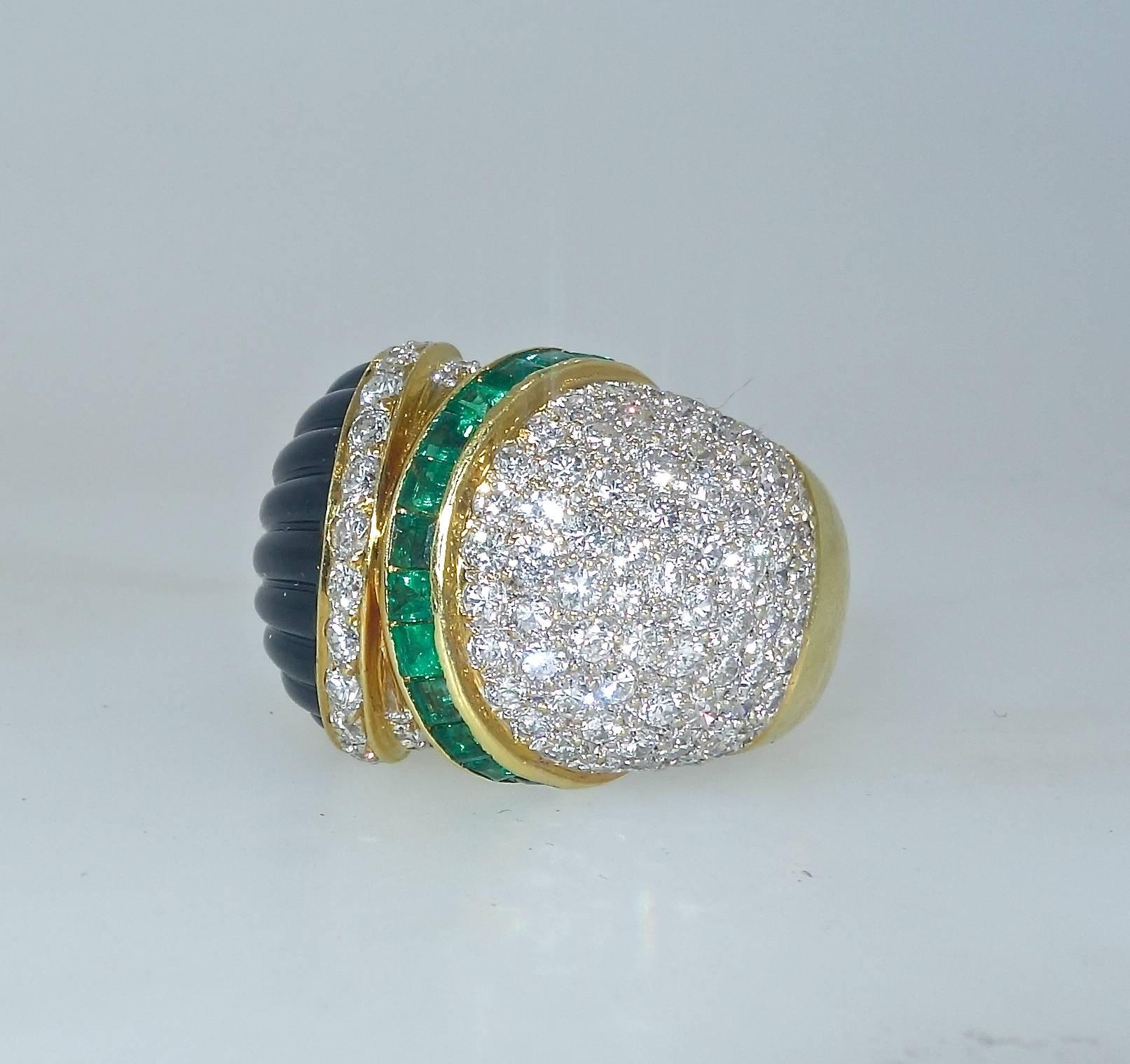 Bold and colorful, this ring has approximately 2.6 cts of fine white diamonds -- all near colorless (H) and very slightly included (VS1).  The natural emeralds are a bright, even, green color.  These stones weigh approximately .50 cts. Creating a