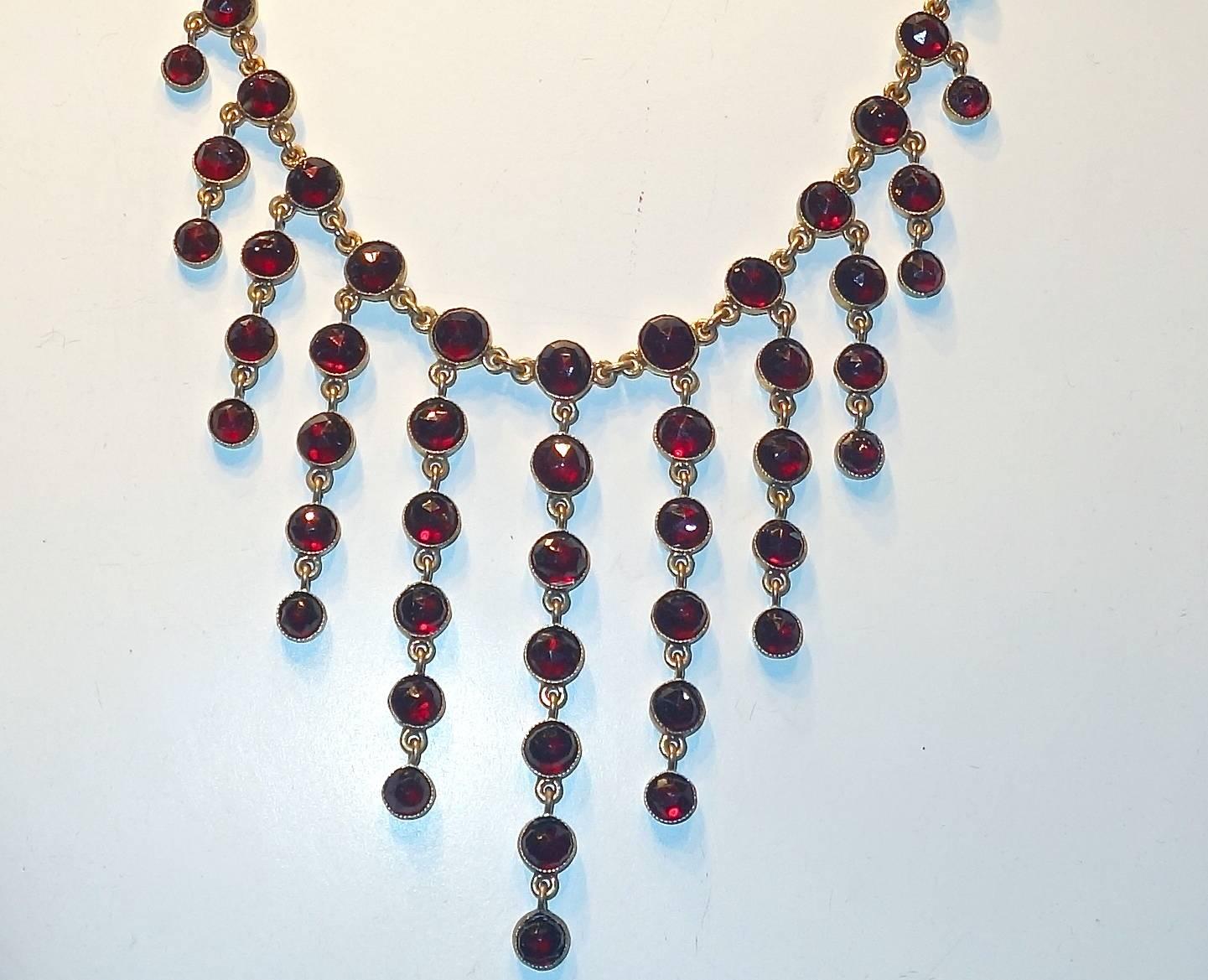 Late 19th century, this piece consisted of milgrained and bezel set rose cut natural garnets in a yellow base metal necklace.  There are 87 deep red natural rose cut garnets - weighing approximately 40 cts.  This antique necklace is 20 inches long