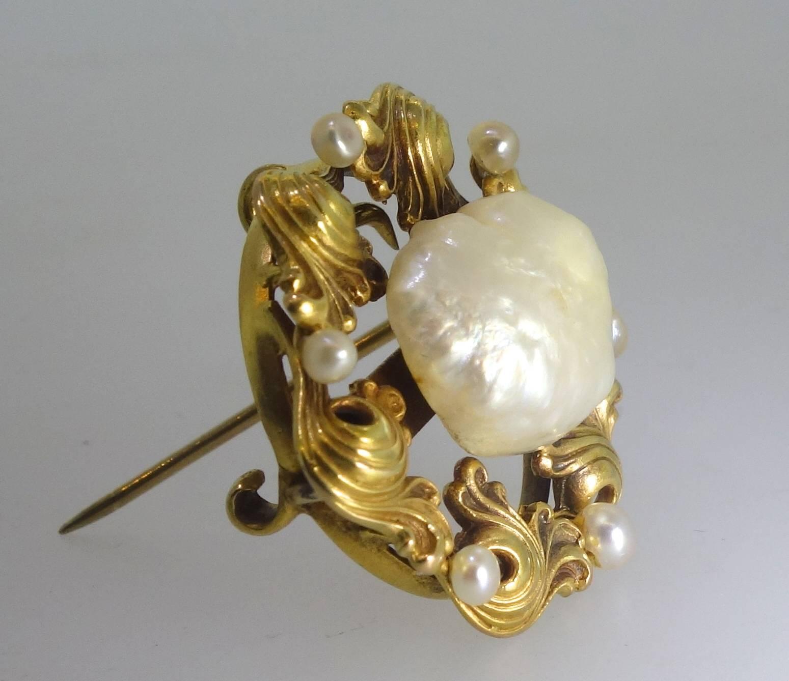 Made at the turn of the century and centering a large natural freshwater pearl surrounded by small natural peals, this piece is 14K and a wonderful example of early workmanship and pearls which are very difficult to fine today because of pollution. 
