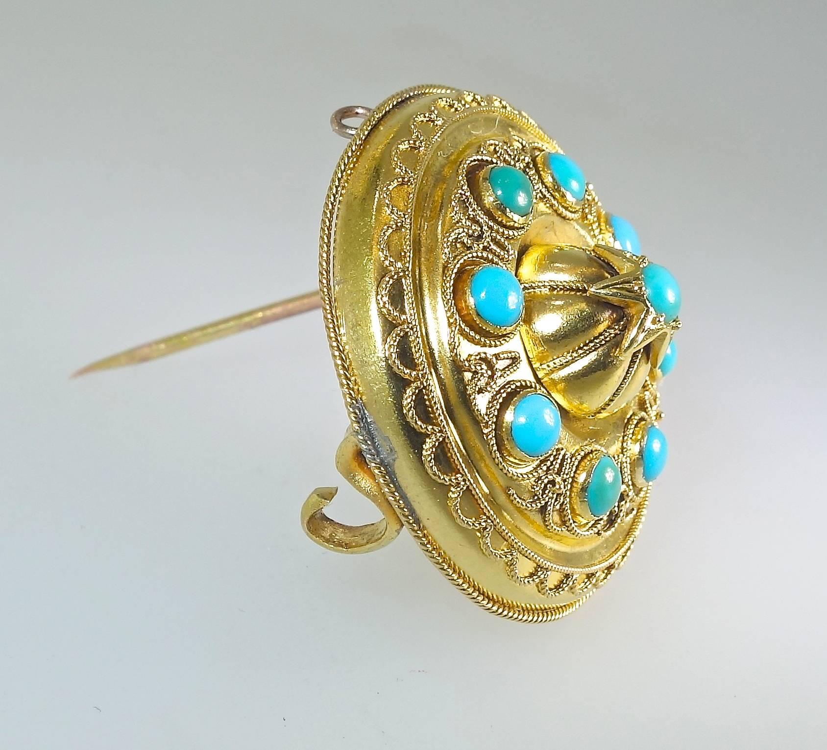 All original, this Victorian brooch has a hair receiver in the back, 9 natural turquoise are bezel set in fine Etruscan revival gold work.  The brooch is 1 1/8 inches in diameter.