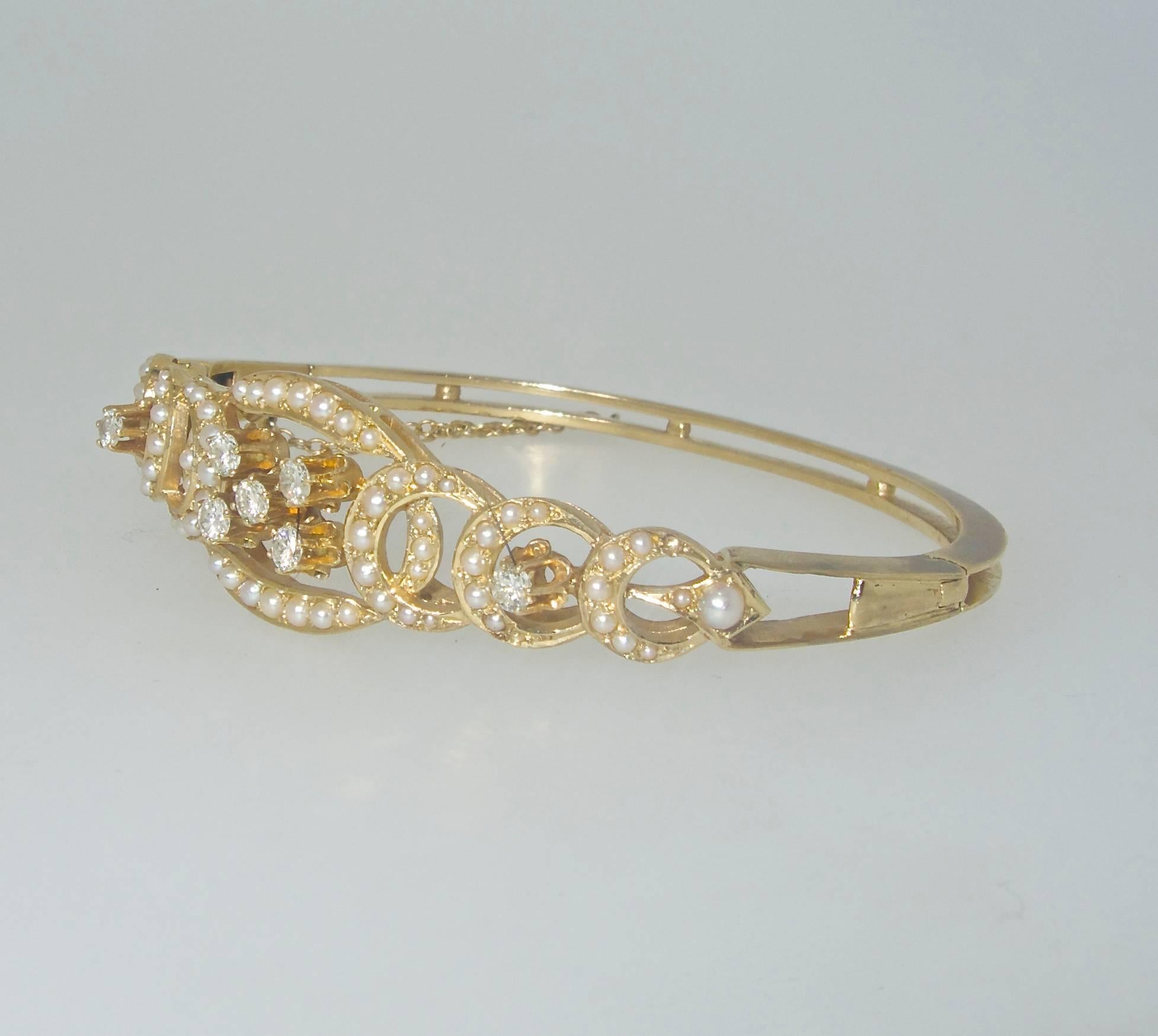 Small seed pearls and diamonds are set into this gold bangle bracelet, it is marked 14K and has the maker's initials KGJ.  There are 68 natural small pearls and 7 round brilliant cut diamonds which weigh approximately .70 cts.  The bracelet is