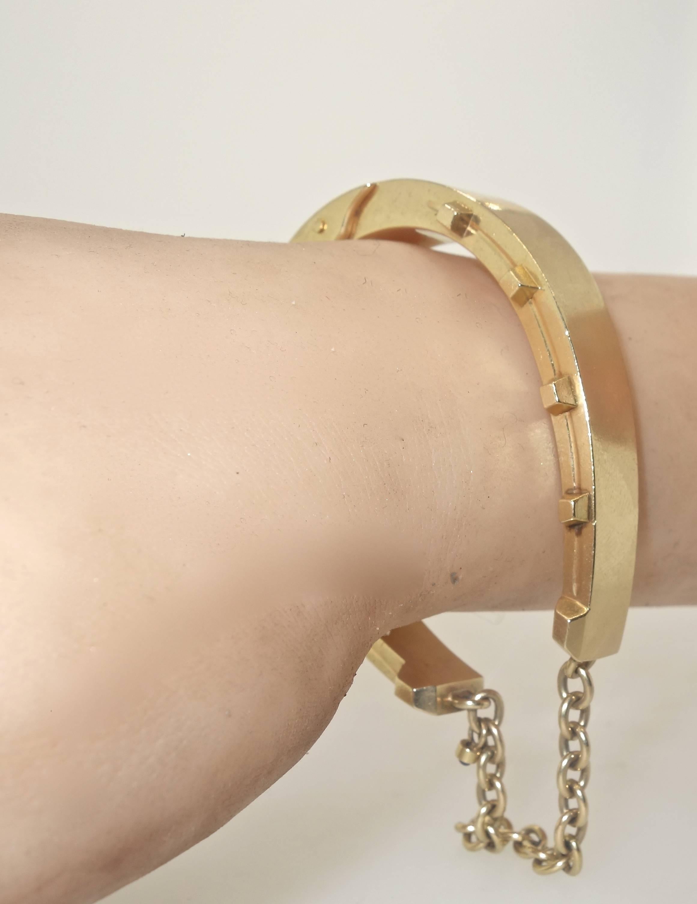 Unusual in design, this gold bangle bracelet opens up wide so that the wrist slips on with ease.  It is an unusual design as it appears as a bold gold bracelet, but the observer soon see that it is in fact the motif of a classic horse shoe. 