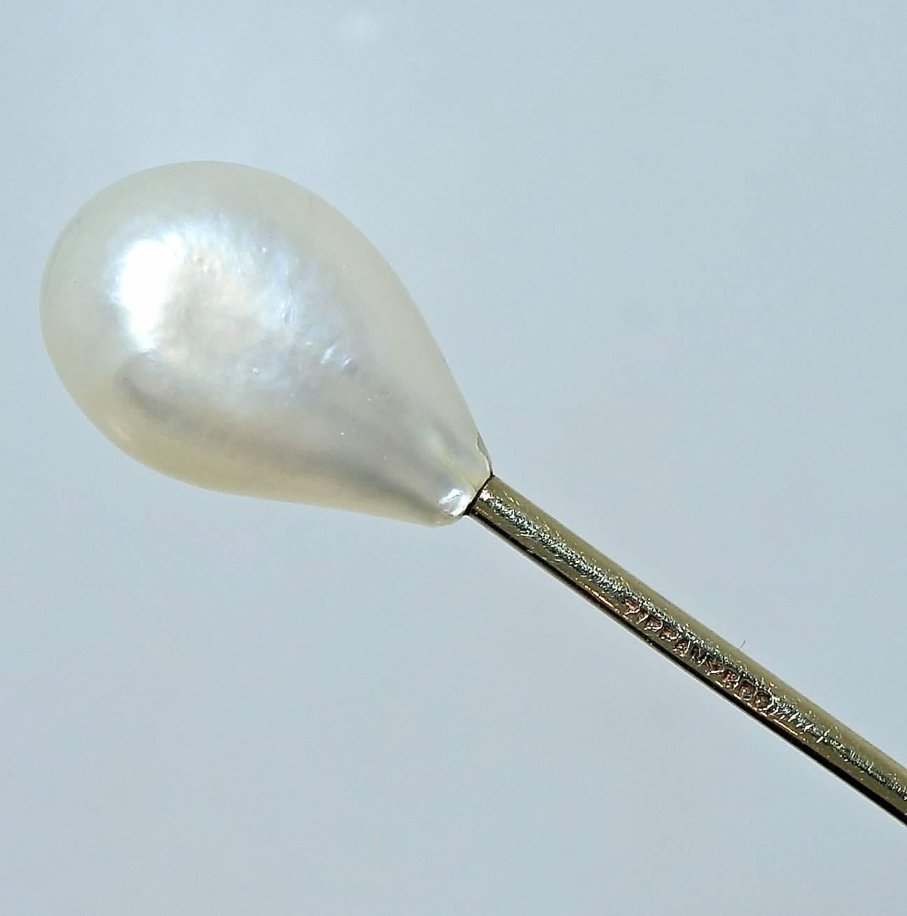 Natural oriental pearl - certified- with smooth skins and deep nacre. 12.45 mm by 8.3 mm.  18K  Antique stickpin by Tiffany & Co.