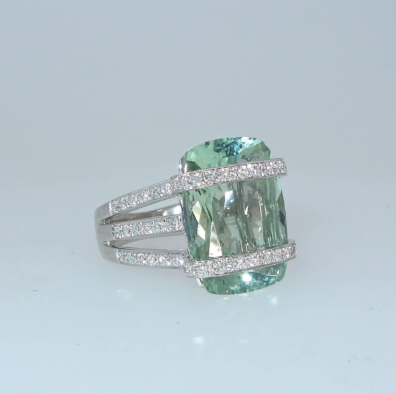 The center natural with, no heat,  cushion cut light blue/green aquamarine weighs approximately 9.5 cts.  It is accented with 85 well matched, well cut white brilliant cut diamonds.  These diamonds are all near colorless (H), and very slightly