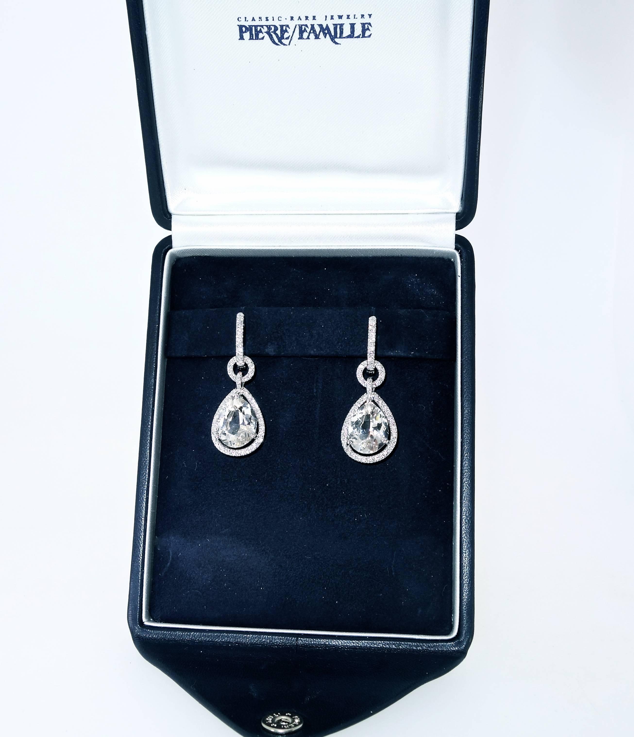 2.50 cts. of well matched, well cut modern round brilliant cut diamonds are set in hand made fine 18K white gold earrings which center a pear cut (diamond cut) white quartz natural stone each weighing approximately 5 cts.  The 112 diamonds are all