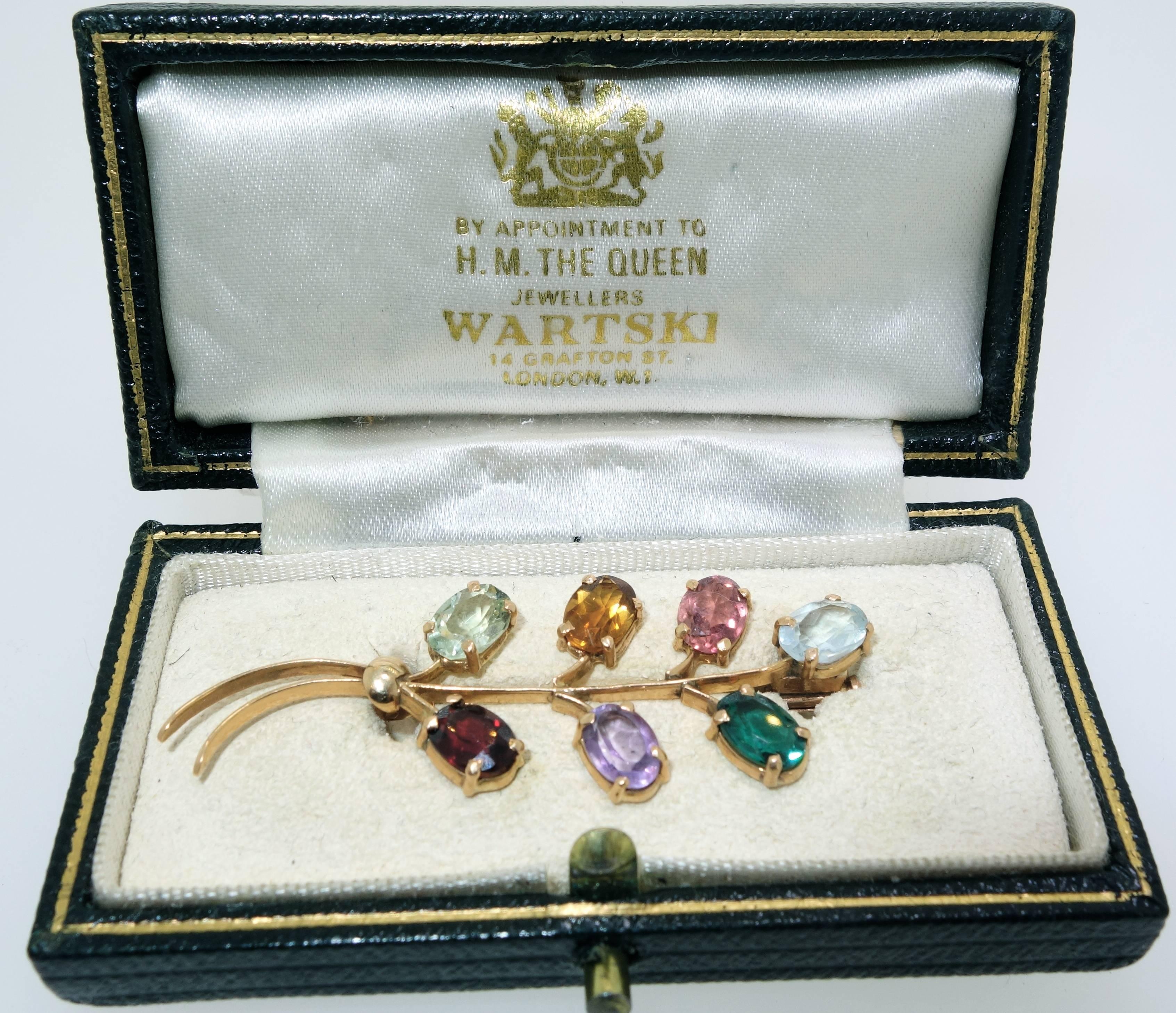 Antique brooch in a fitted box  by Warski London, (however, not signed), this 18K antique piece possess all natural stones: Aquamarine, tourmaline, amethyst, garnet, and citrine.  This colorful bouquet is just over two inches in length. 