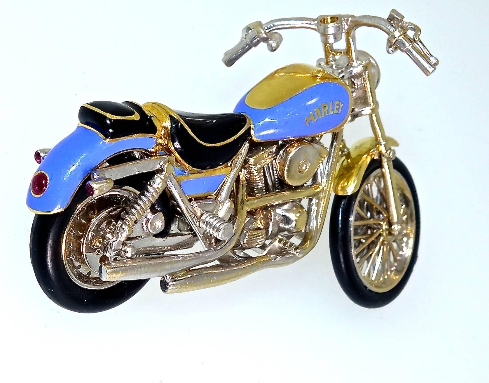 Hand made with intricate workmanship of a Harley motorcycle brooch with bright blue enamel and accented with a headlight of a.50 ct. white diamonds (H,VS), near colorless and very slightly included, smaller diamonds on the handle bars, and a natural
