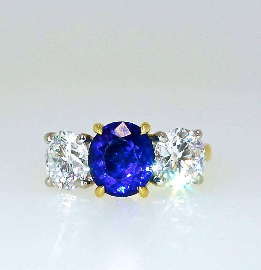 Fine natural unheated bright blue sapphire, (A.G.L. certified), weighing 3.01 cts., is accented by 2.21 cts of G.I.A. graded colorless (D) round diamonds which are also VVS (very very slightly included).  This ring is 18K and platinum, signed