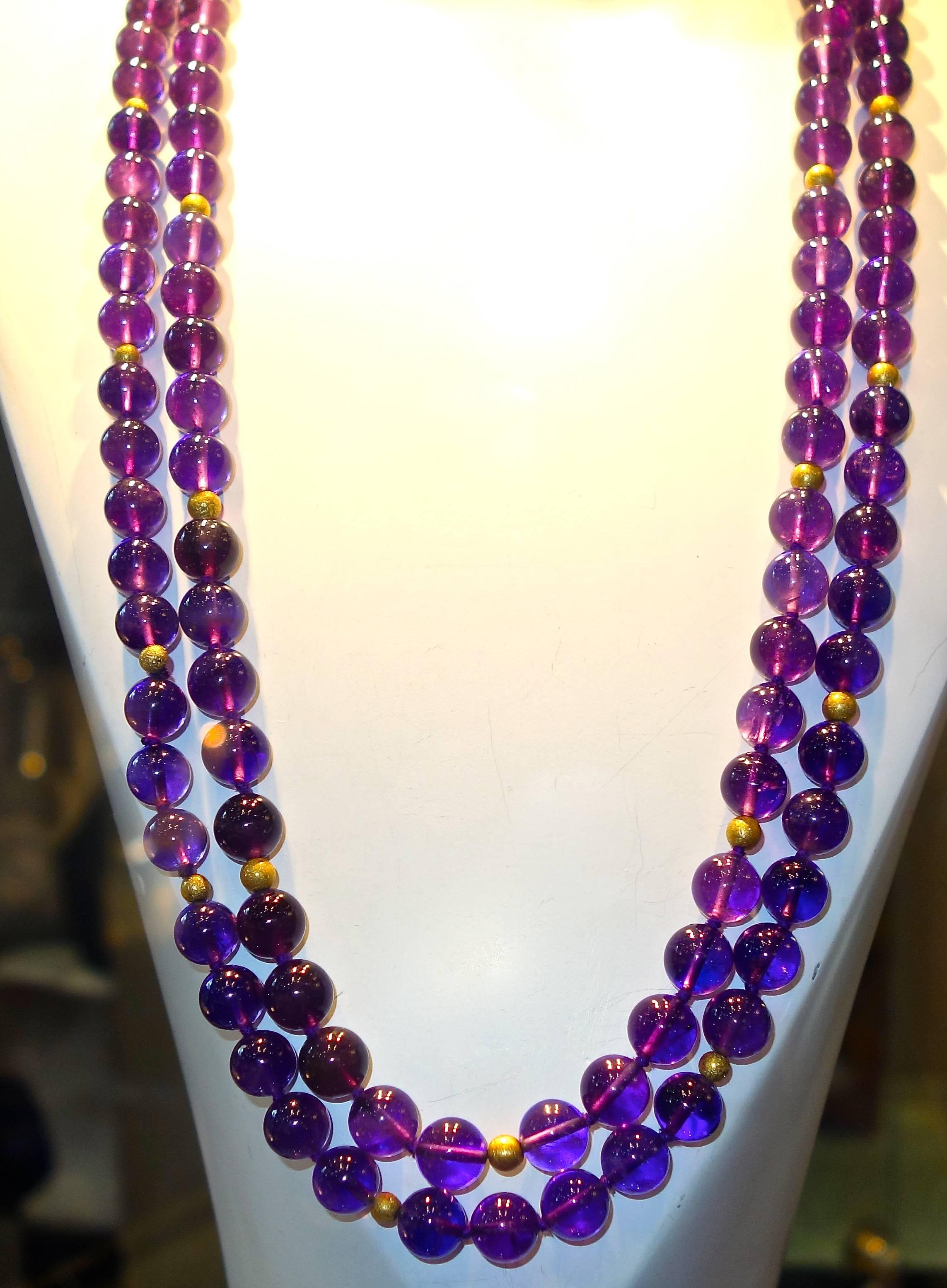 Fine bright purple amethyst beads weighing approximately 875 cts are interspersed with 28 18K gold beads.  This long sautoir is 63 inches in length and the beads range from 9.5 to 10 mm.  All of the amethyst are bright and clear.