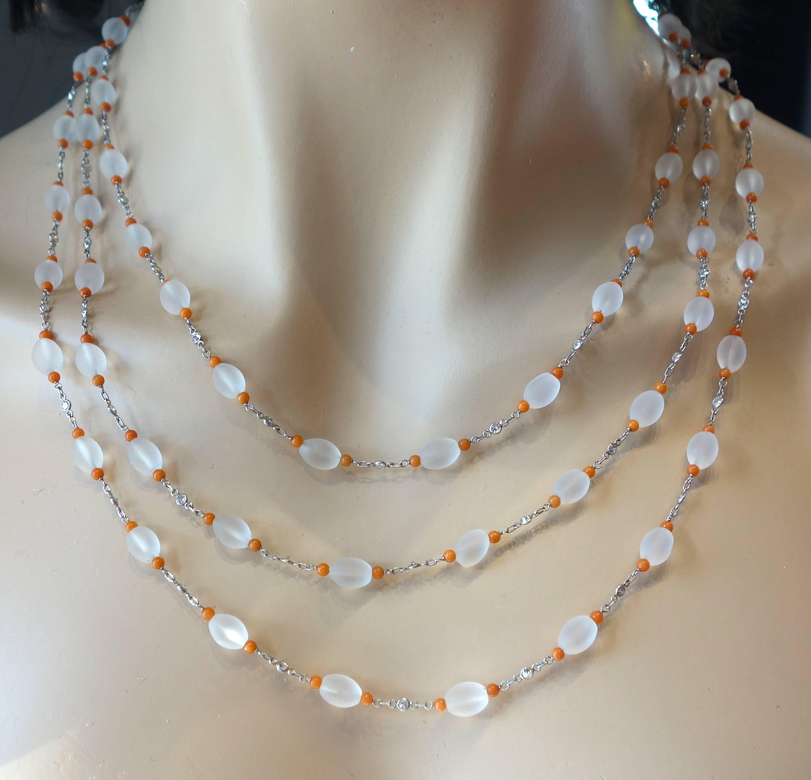This long chain possesses frosted Rock Crystal interspersed with bright orange coral beads and diamonds.  The necklace is 67 inches long and can be worn a variety of lengths.  The diamonds are all round brilliant cut, near colorless and slightly