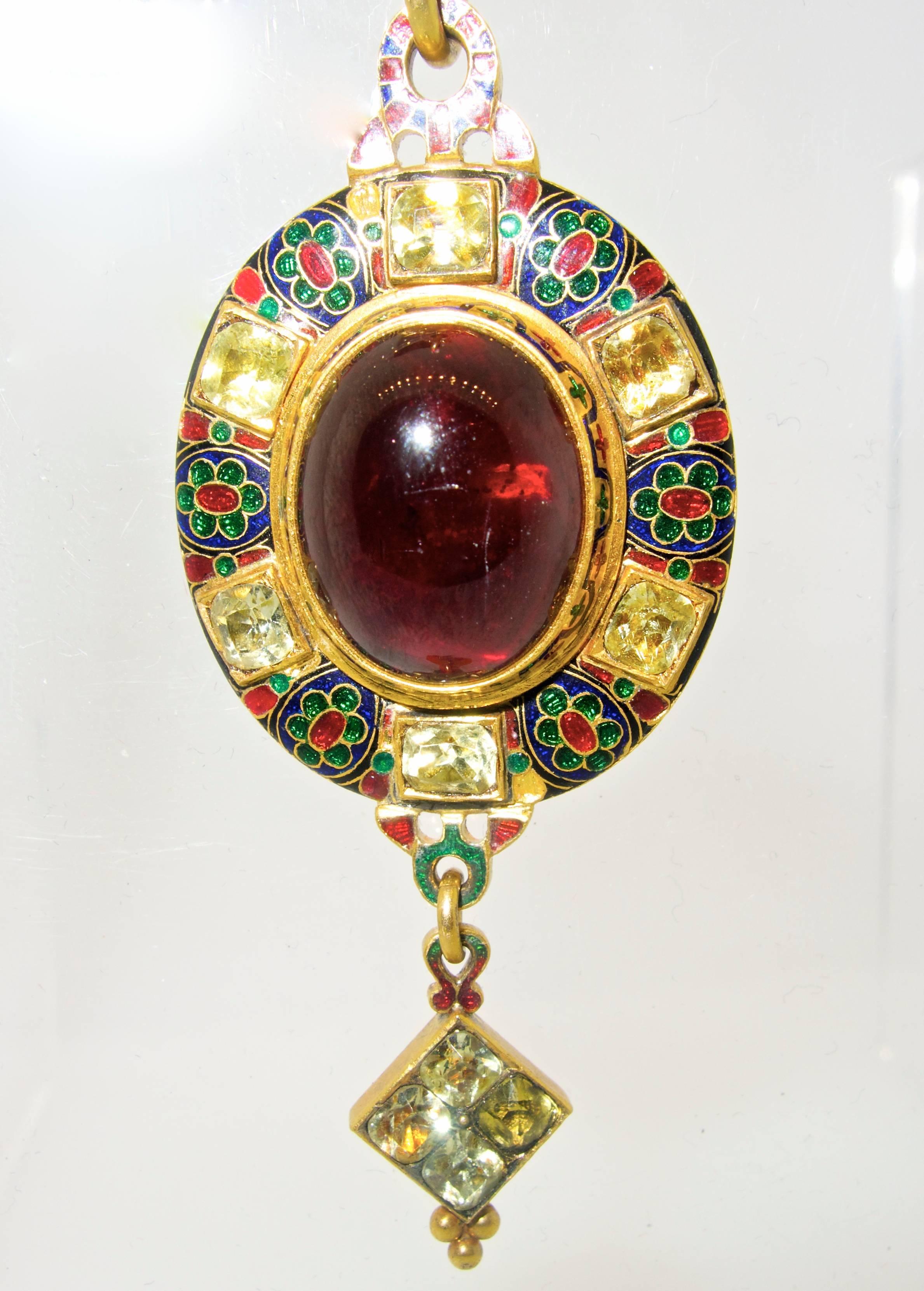 Also referred to as Holbeinesque jewelry, because similar pieces can be seen in many of his paintings, this pendant necklace and earrings centers an oval cabachon cut deep red garnet surrounded by colorful enamel and antique cut chrysoberyl stones. 